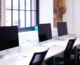 Row of three Mac books  in classroom